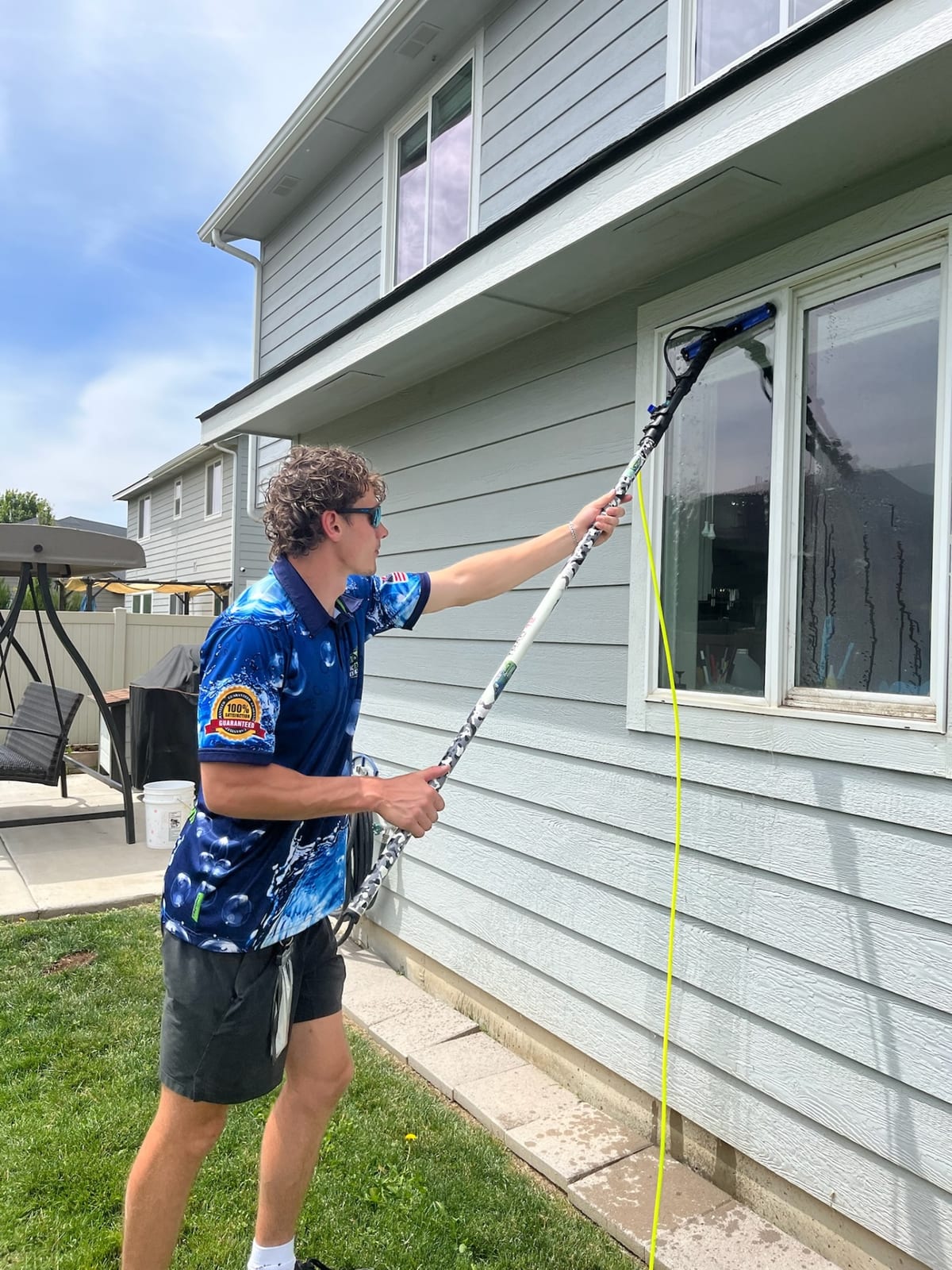 Epic Exterior Services technician cleaning windows with a water-fed pole in the Treasure Valley
